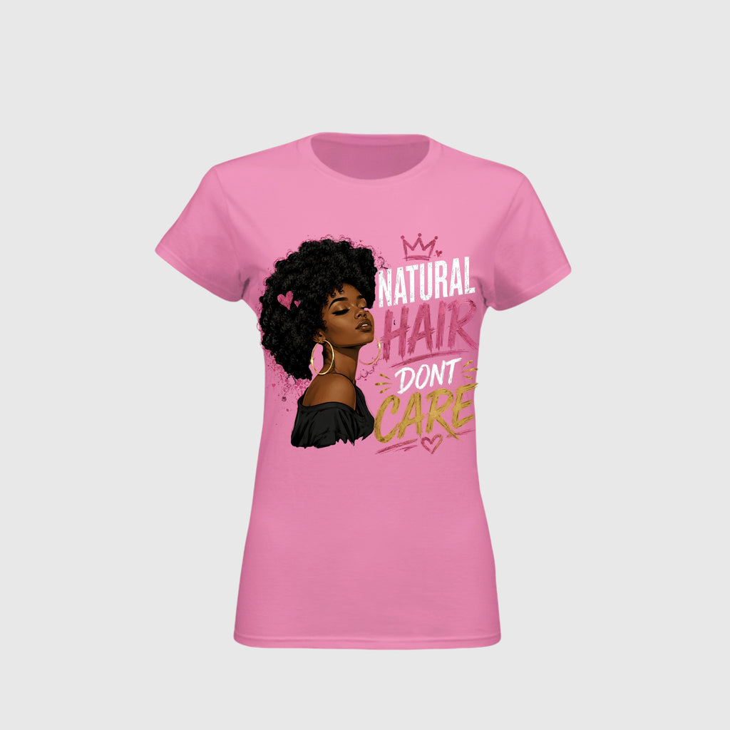 A pink short-sleeve crewneck t-shirt featuring a graphic of a woman with an afro and the text 'NATURAL HAIR DON'T CARE' in white, pink, and gold lettering, displayed on a light gray background.