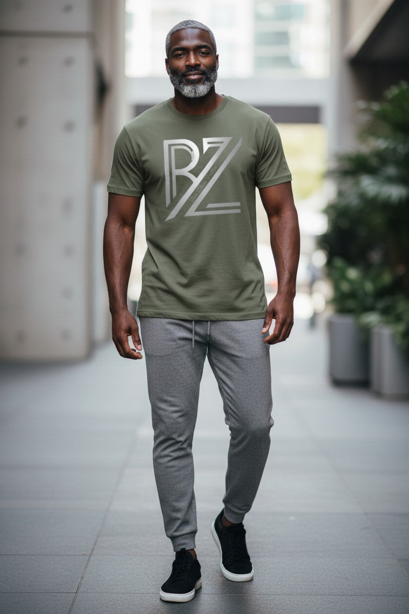 Man wearing a green t-shirt with a logo and gray pants in an indoor setting