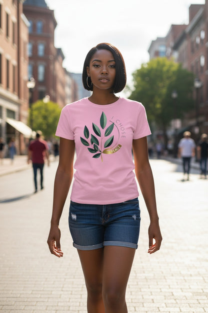 Woman wearing a pink t-shirt with a leaf design on a city street