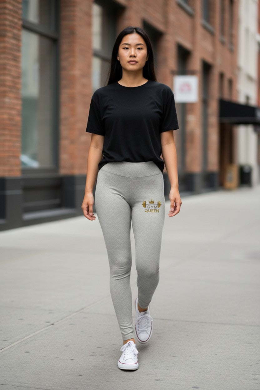 Woman wearing a black t-shirt and gray leggings with a logo, walking on a city street.