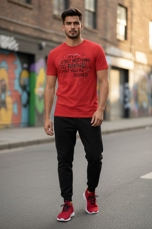 Man wearing a red t-shirt with text, black pants, and red shoes on a street with graffiti.