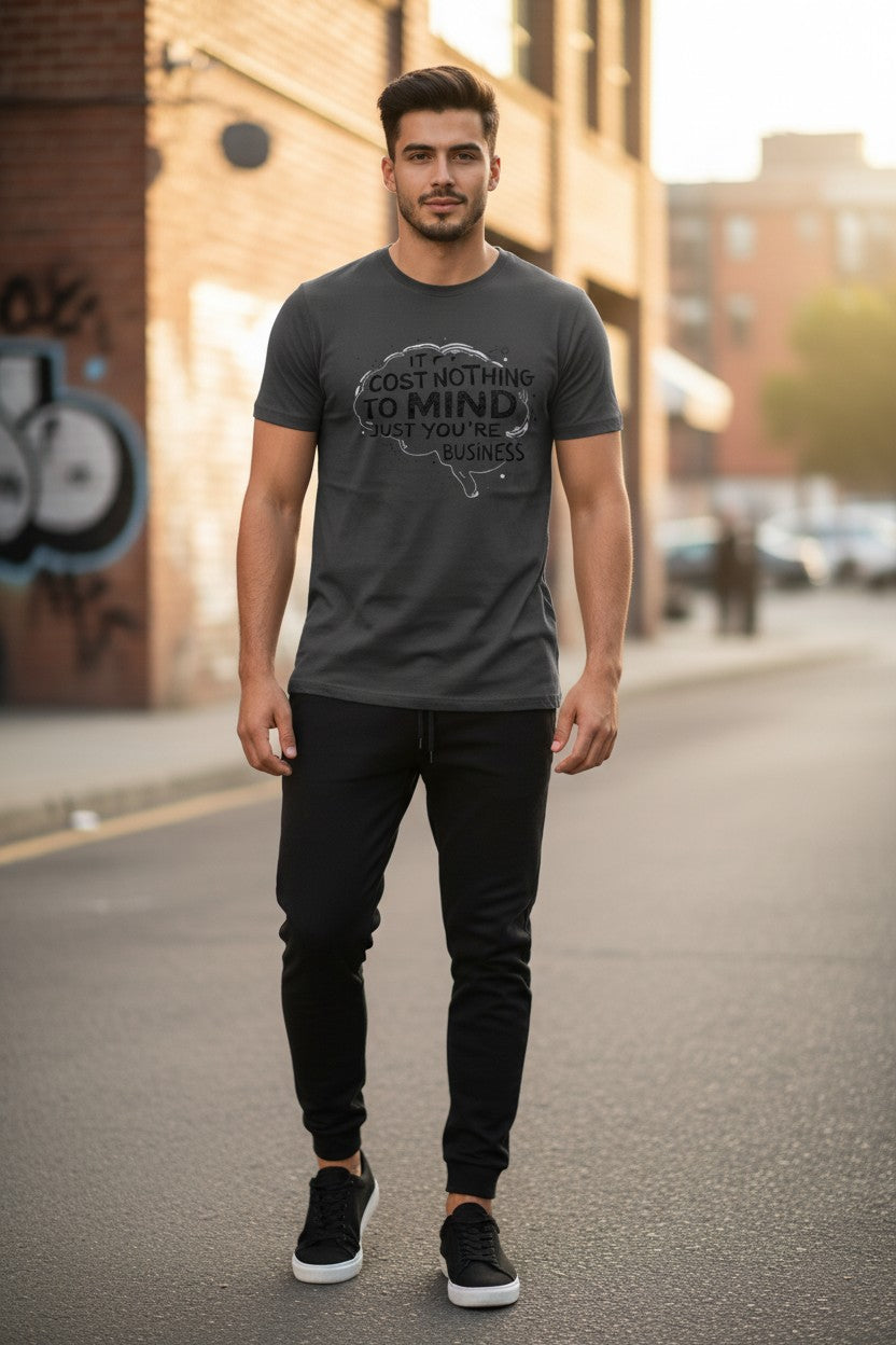 Man wearing a dark gray t-shirt with a graphic design on a city street.