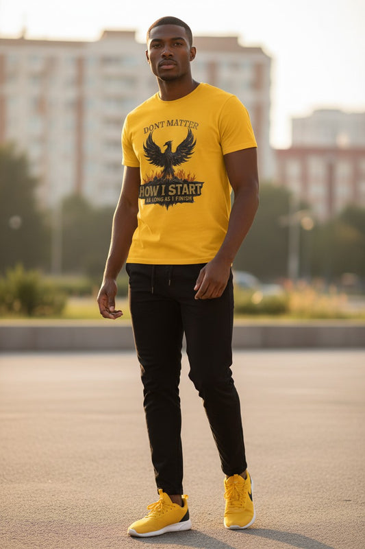 Man wearing a yellow t-shirt with an eagle design and text, standing outdoors.