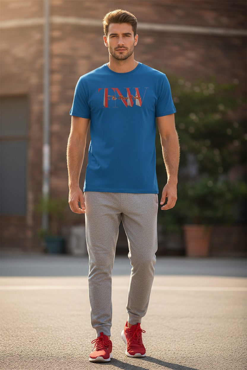 Man wearing a blue t-shirt with a graphic design, gray pants, and red shoes standing outdoors.