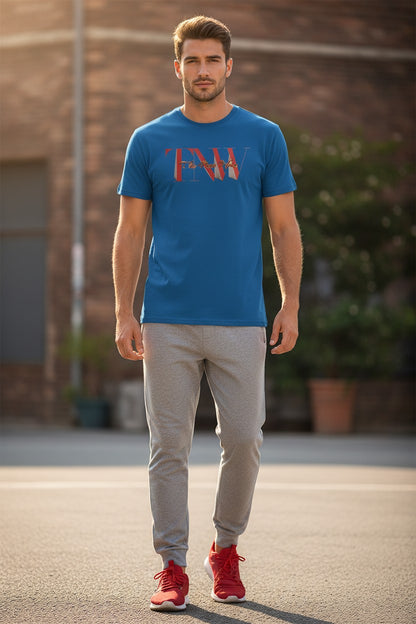 Man wearing a blue t-shirt with a graphic design, gray pants, and red shoes standing outdoors.