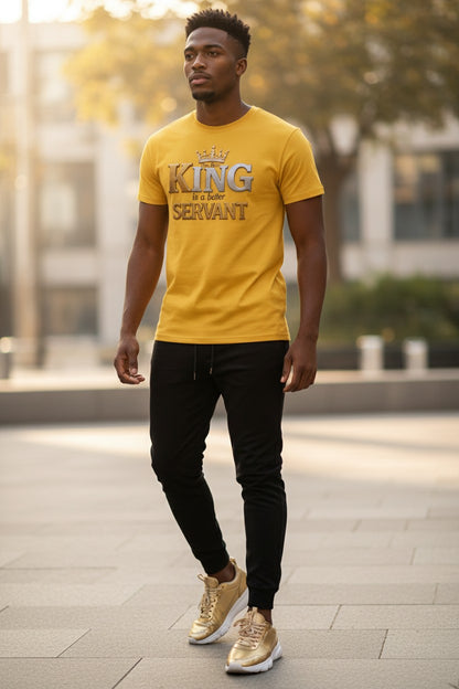 Man wearing a yellow t-shirt with text, black pants, and gold shoes walking outdoors.
