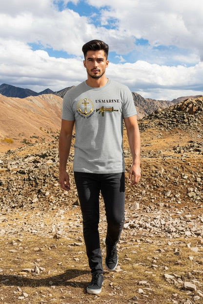 Man wearing a gray t-shirt with a US Marine logo in a mountainous landscape