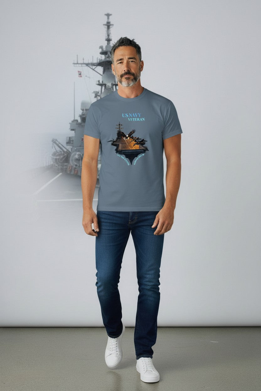 Man wearing a gray t-shirt with a graphic design, standing in front of a ship model on a white background