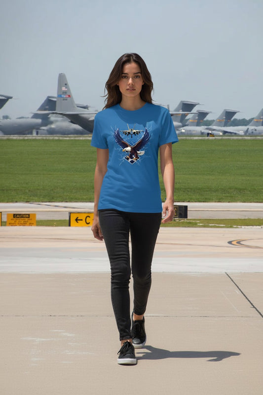 Woman wearing a blue t-shirt with an eagle design at an airfield.