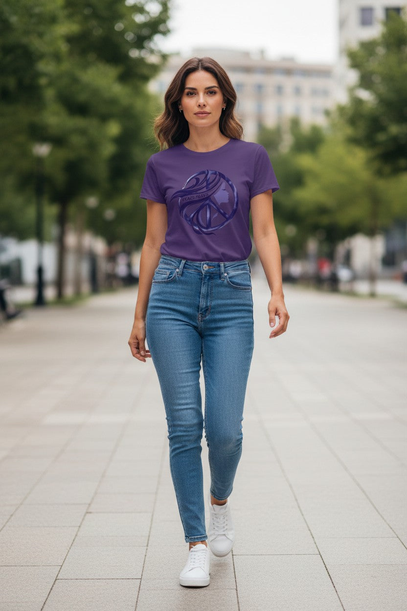 Woman wearing a purple t-shirt with a graphic design and blue jeans walking on a sidewalk.