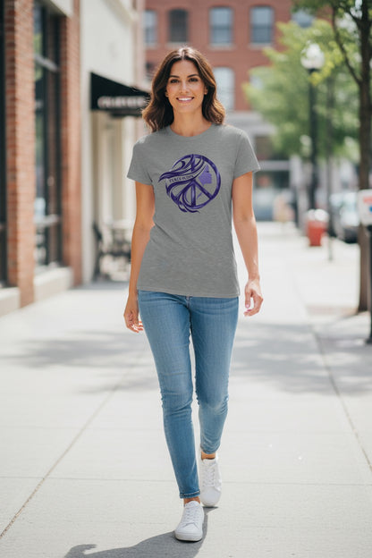 Woman wearing a gray t-shirt with a purple logo on a city street.