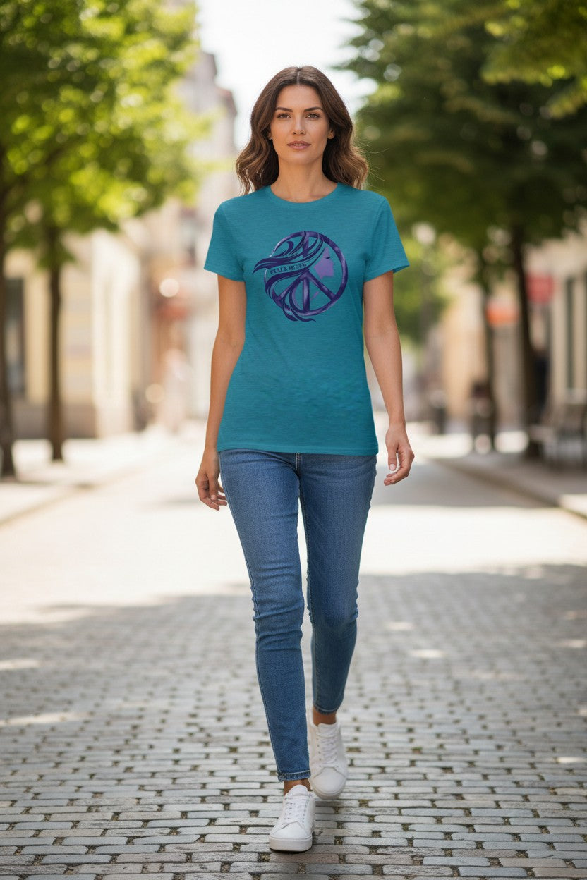 Woman wearing a teal t-shirt with a purple graphic design on a city street.