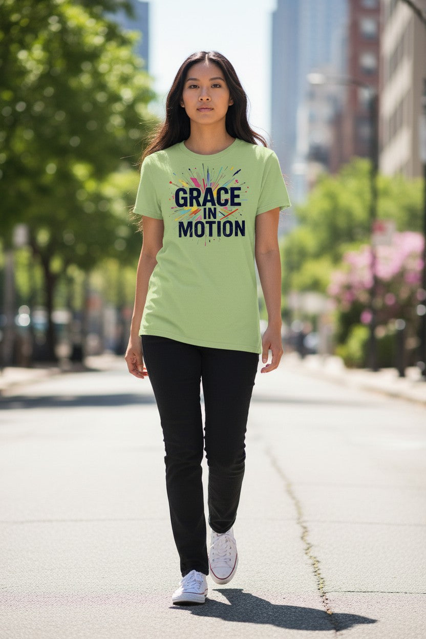 Woman wearing a green t-shirt with 'Grace in Motion' text on a city street.