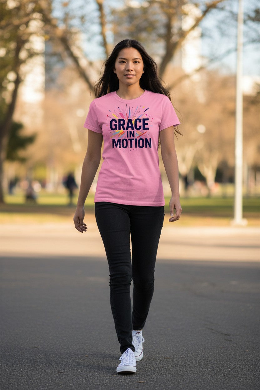 Woman wearing a pink 'GRACE IN MOTION' t-shirt walking outdoors.