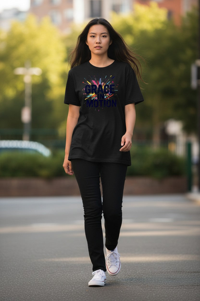 Woman walking on a street wearing a black t-shirt with colorful text and graphics.