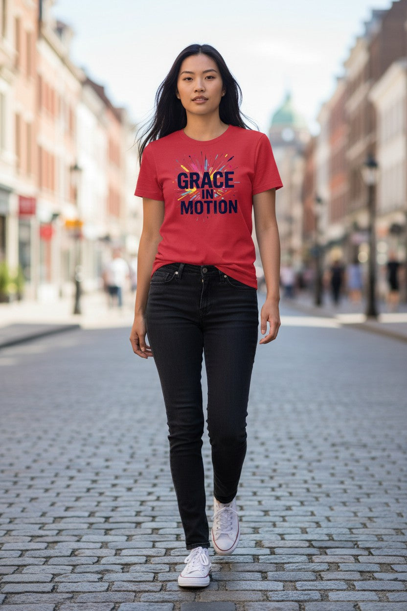 Woman wearing a red t-shirt with 'Grace in Motion' text on a city street.