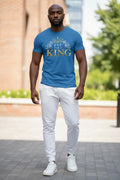 Man wearing a blue t-shirt with text standing outdoors.
